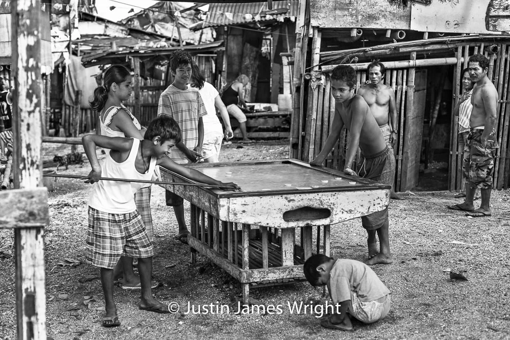 Recreation . - An occasional game of pitsa (Filipino billiards with discs), well-deserved reward at the end of a day’s work. Resilience - The Isla Pulo Community, Philippines. February 2013. Canon EOS Mk III, EF 50 mm, F 2.8, 1/500 sec.