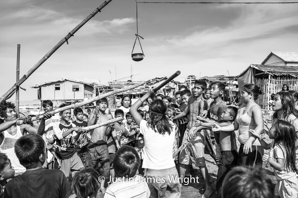 Basagang Palayok (hit the pot) A traditional party game. Resilience - The Isla Pulo Community, Philippines. December 2013. Canon EOS Mk III, EF 35 mm, F 4.0, 1/250 sec. (Above and Below)