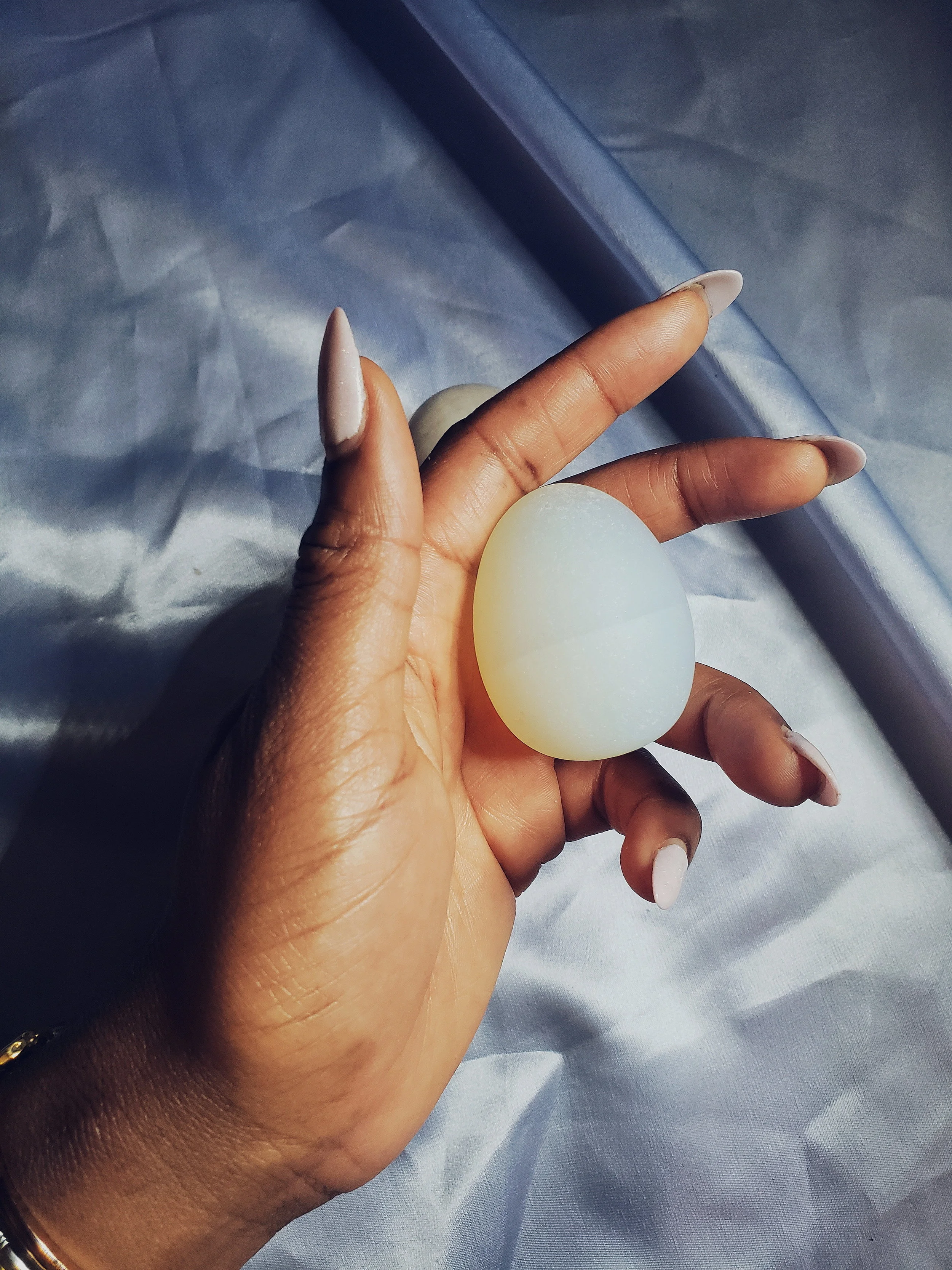 Pictured here: Bria holds a Opalite yoni egg, size medium in her hands