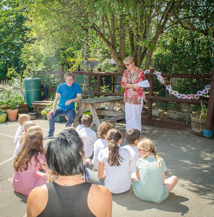 Head Teacher, Ms Susan Adams, gives a speech before handing me the scissors to cut the ribbon of doughnuts. (Photo by Emerson Wimsey)
