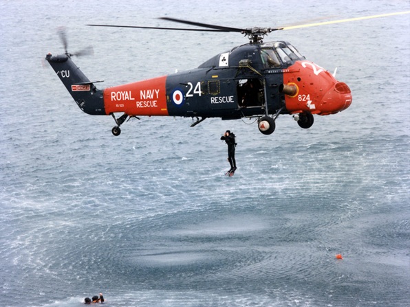 771 NAS Wessex as a rescue swimmer/diver launches himself into the water. Copyright of the Royal Navy/MOD.