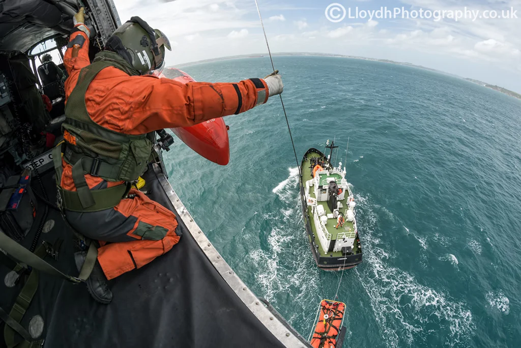Pilot, winch operator and aircrewman all pictured in one photo as they conduct winching ops with a civilian vessel off the coast of Cornwall. 