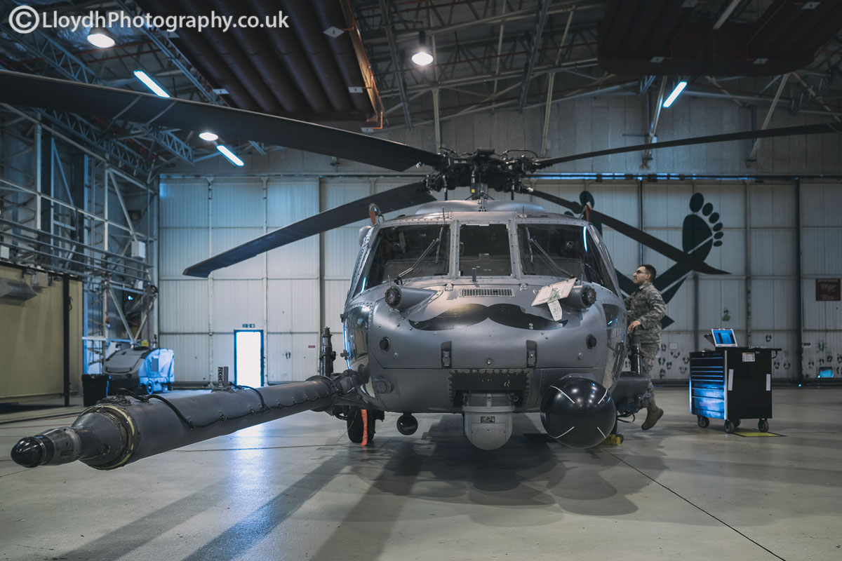 HH-60G Pave Hawk undergoing maintenance work, the iconic green feet printed on the hangar doors.
