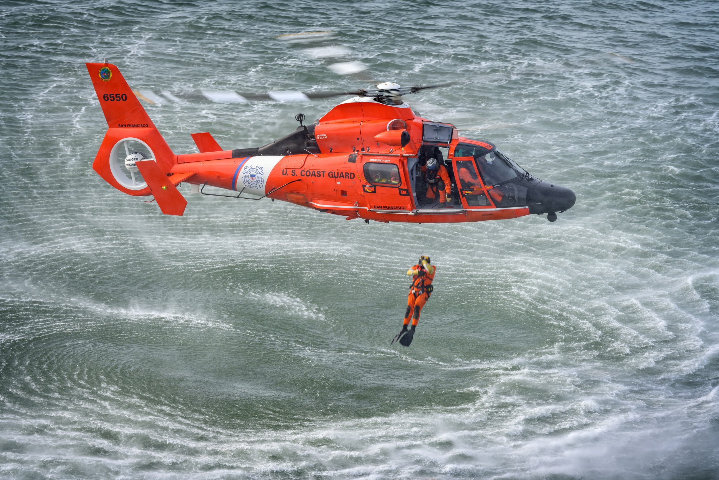 Rescue swimmer jumps from a United States Coast Guard Airbus MH-65E Dolphin