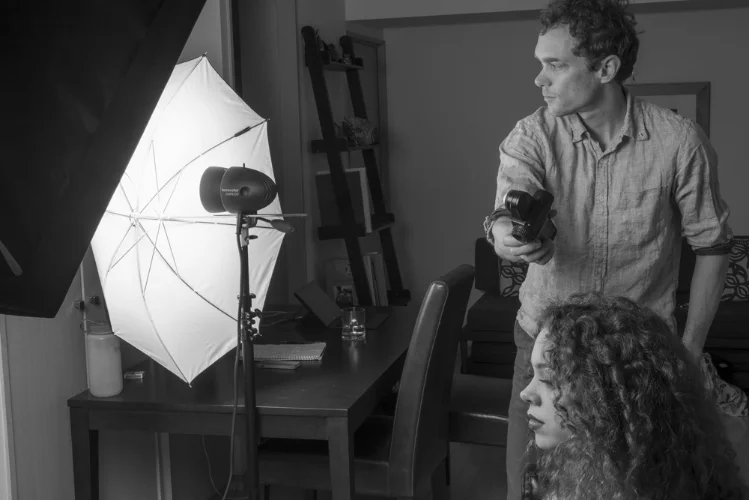 Metering the umbrella, which is being used as a fill light in this instance. The main light is the softbox that is seen in the upper left corner of the image. The main light would typically be blocked from the meter while I meter the fill light but I wanted you to see the meter in this image.
