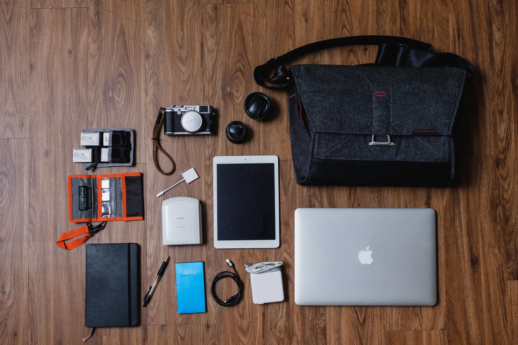 This is my travel setup 'Lets go somewhere bag' - Think Tank Photo Battery Holder, 4x Fujifilm NP-95 Batteries, Think Tank Photo SD Pixel Pocket Rocket, SD Cards, Moleskine notebook with Pilot G-2 Pen, Fujifilm X100s camera, Fujifilm WCL-X100 & TCL-X100 Conversion Lenses , Apple iPad Air, Apple Lighting to SD Card Adapter, Fujifilm Instax Printer SP-1 , Portable charger, Apple Lighting to USB Cable, Apple MagSafe Charger, and Apple Macbook Pro 15"