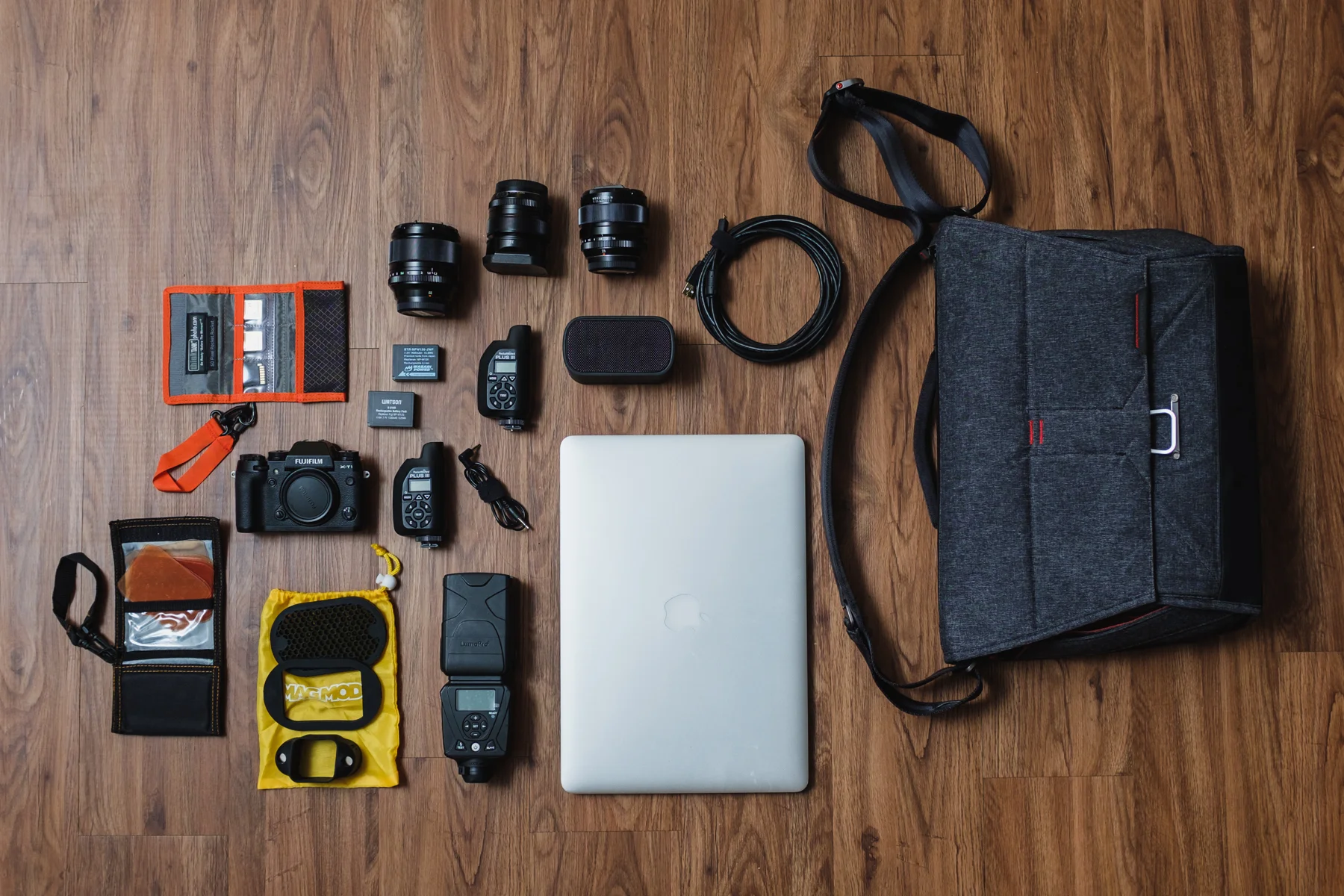 Quick shoot setup "I don't have an assistant and need a quick shoot bag" - This loads up the bag very tightly. Think Tank Photo SD Pixel Pocket Rocket , SD Cards, Fujifilm X-T1 Camera, Fujifilm NP-W126 Batteries, Fujifilm 56mm, 35mm, & 23mm Lenses, 2x PocketWizard Plus III Transceiver, Sync cord, MagMod Gel Kit, MagMod Basic Kit (Grid, Gel Slot, & MagGrip), Lumopro LP-180 Flash, UE Bluetooth Speaker, USB Tethering Cable, and Apple Macbook Pro 15"