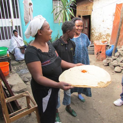 Neighbors offer the gift of Injera with ground hot pepper