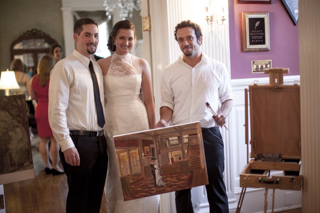 Live Wedding Painter Ben Keys of Wed on Canvas standing with bride and groom's new wedding painting.  // The Graystone Inn, Wilmington, NC // Photo Courtesy of Blueberry Creative
