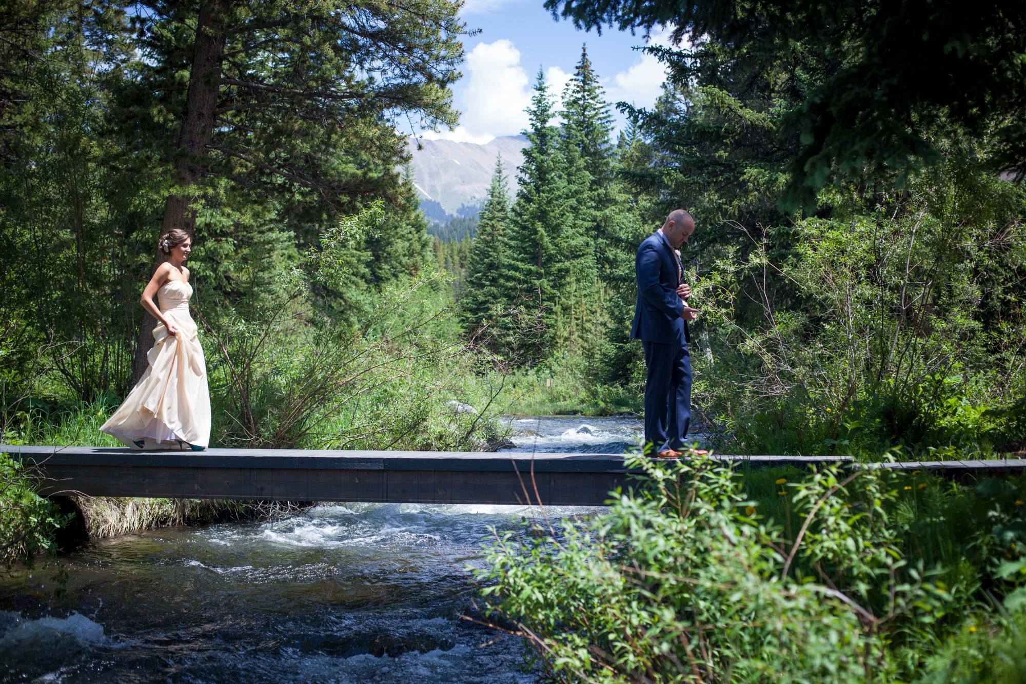 best-first-look-photo-bride-walking-across-bridge-breckenridge-colorado-wedding-painter-ben-keys-wed-on-canvas