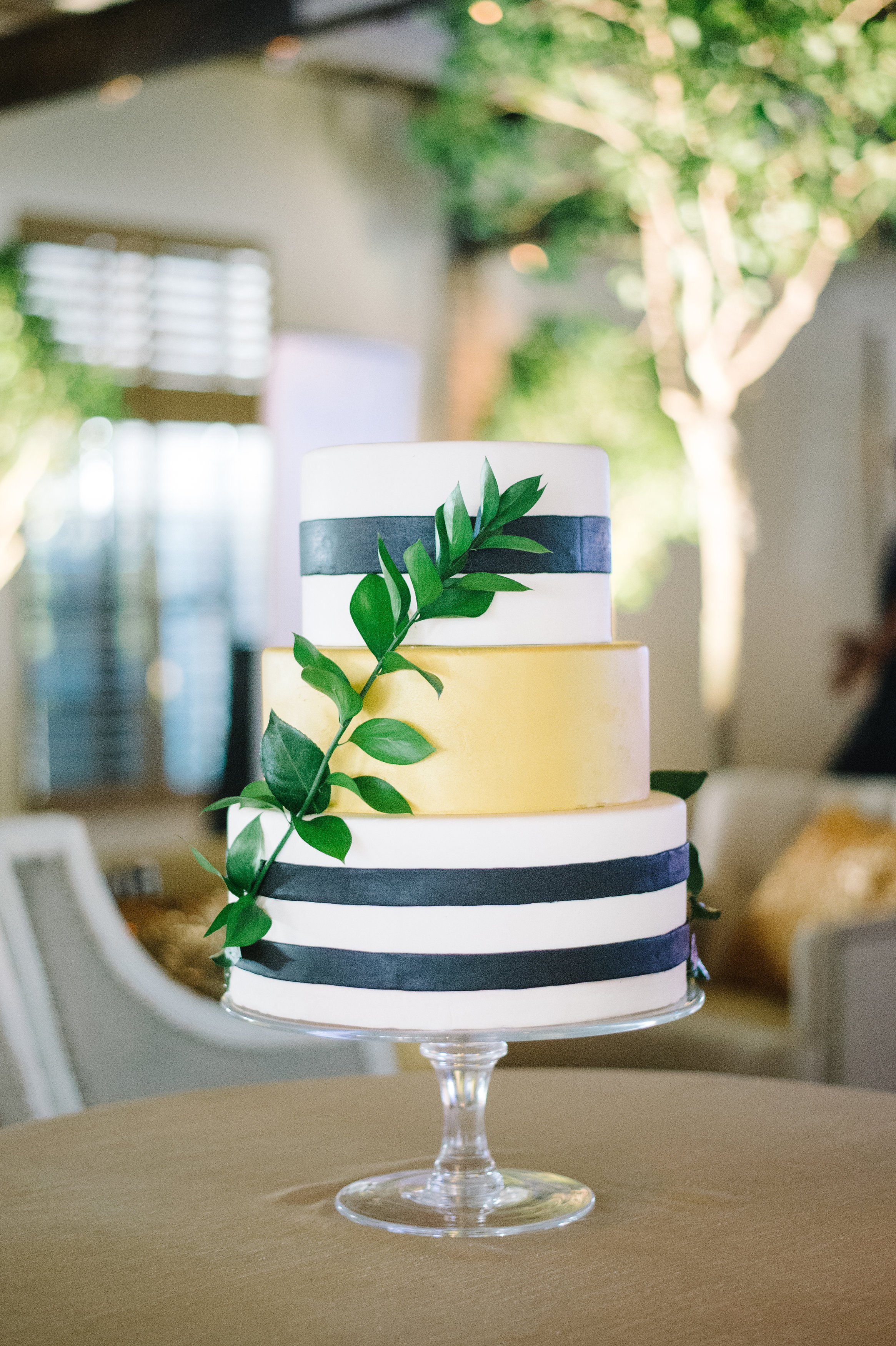 black-and-white-striped-caked-with-gold-center-and-greenery-wrapping-around-charleston-delicious-desserts-the-knot-market-mixer-cannon-green