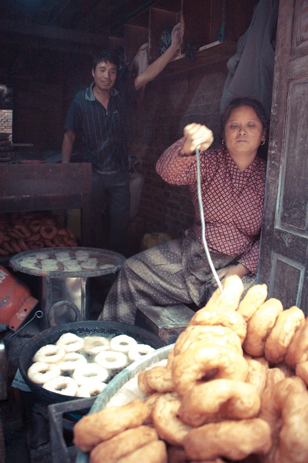 a woman fries doughnuts and sells them in Bhaktapur, Nepal.jpg