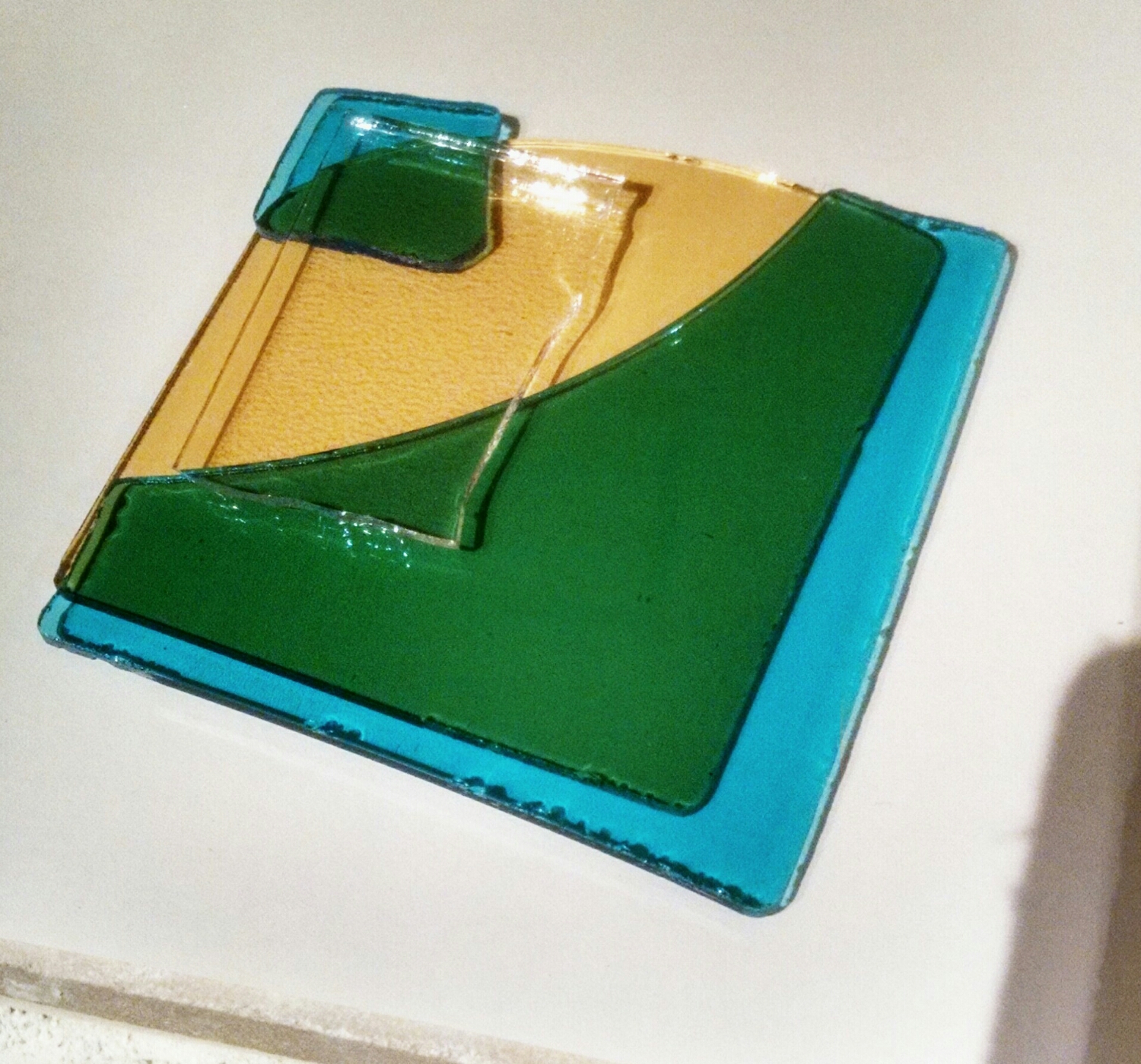 The edge to the right sites that the glass is actually blue, until layered on top of yellow...blue+yellow=green.