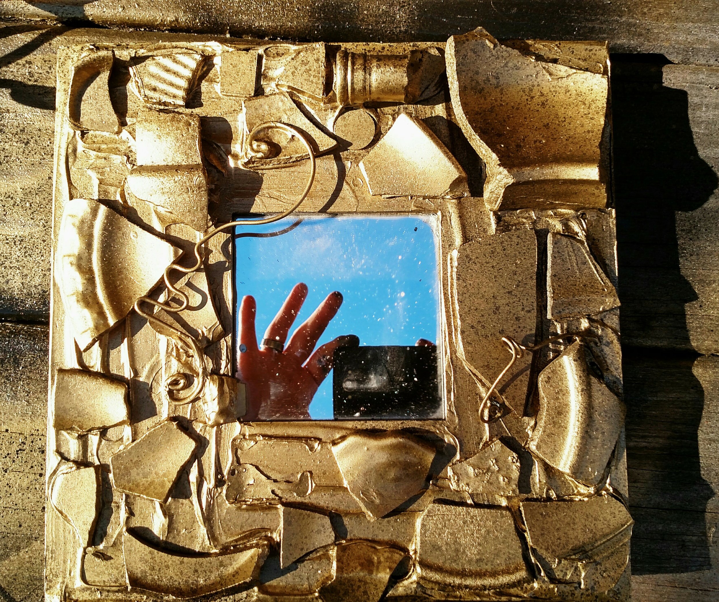 Gold frame blue sky mirror camera and fingers.jpg