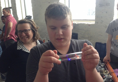 Jon, holding some sort of tube with lights in it at the Science Festival