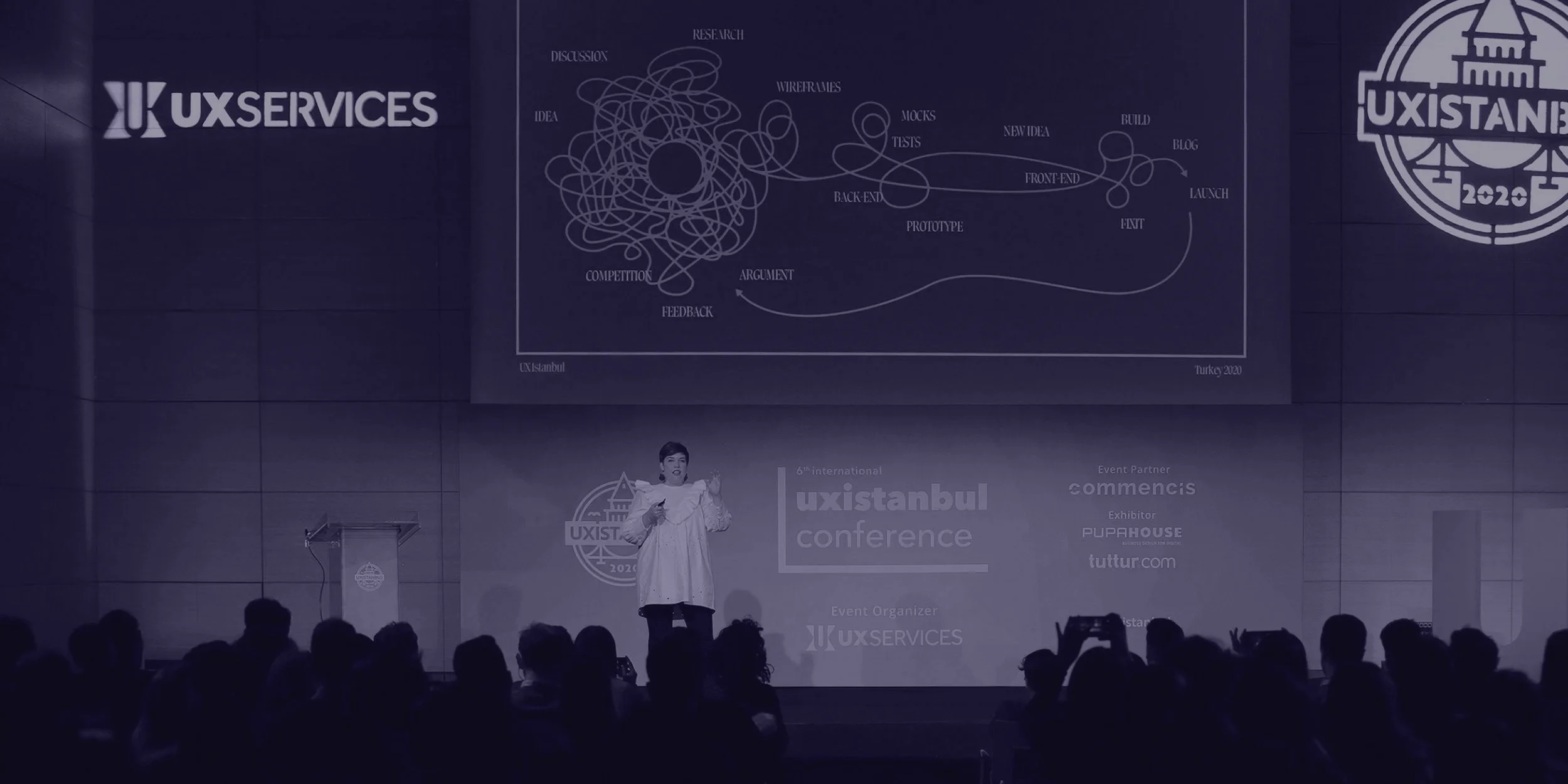 UXservices branding displayed on stage at the UXistanbul conference