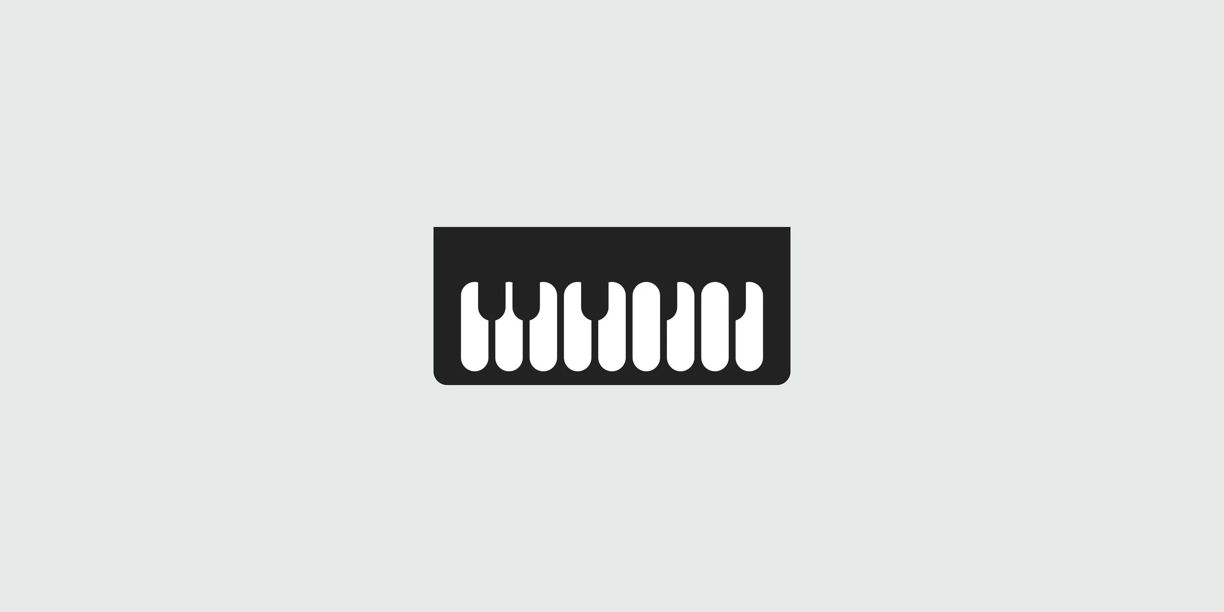 Black MannMusic piano keyboard symbol on a light gray background, featuring rounded geometric shapes and negative space.