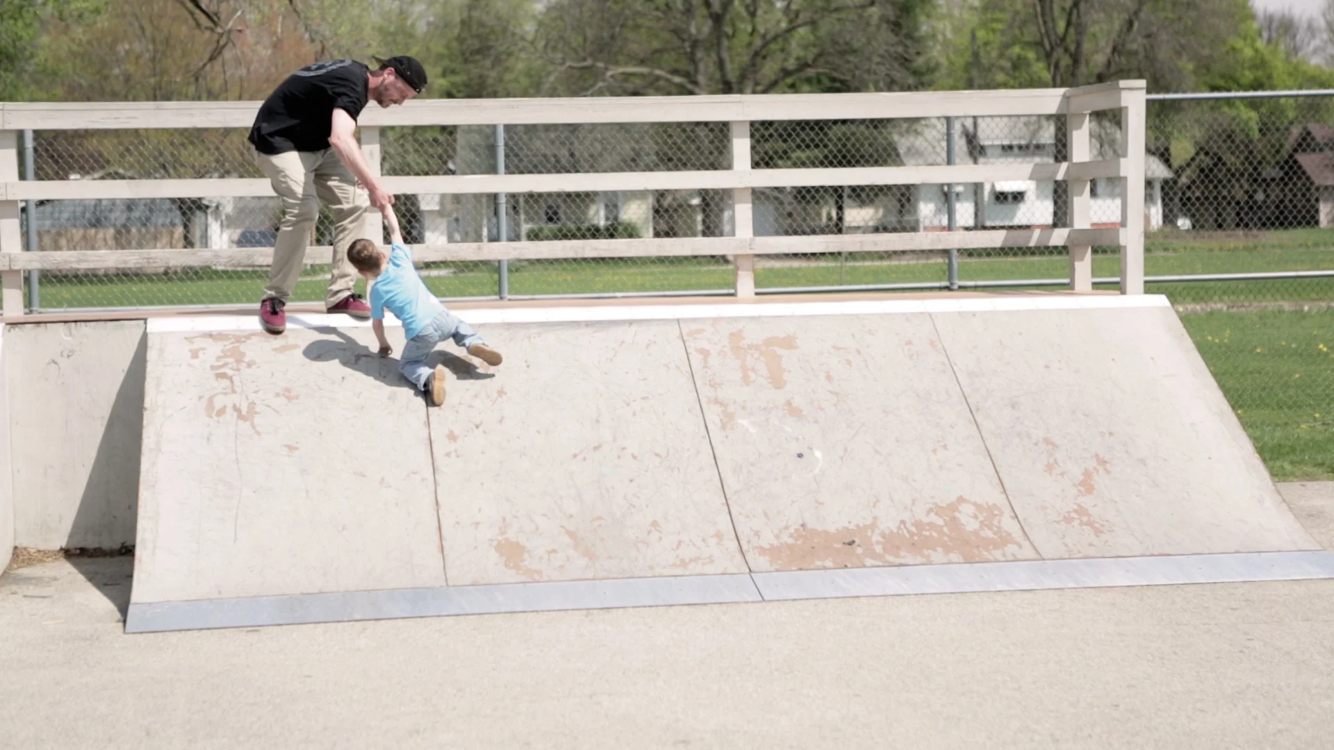 Eric helps Johnny, his second son, crest the ramp at Churchill Park, a neighborhood skatepark he lobbied to get built.