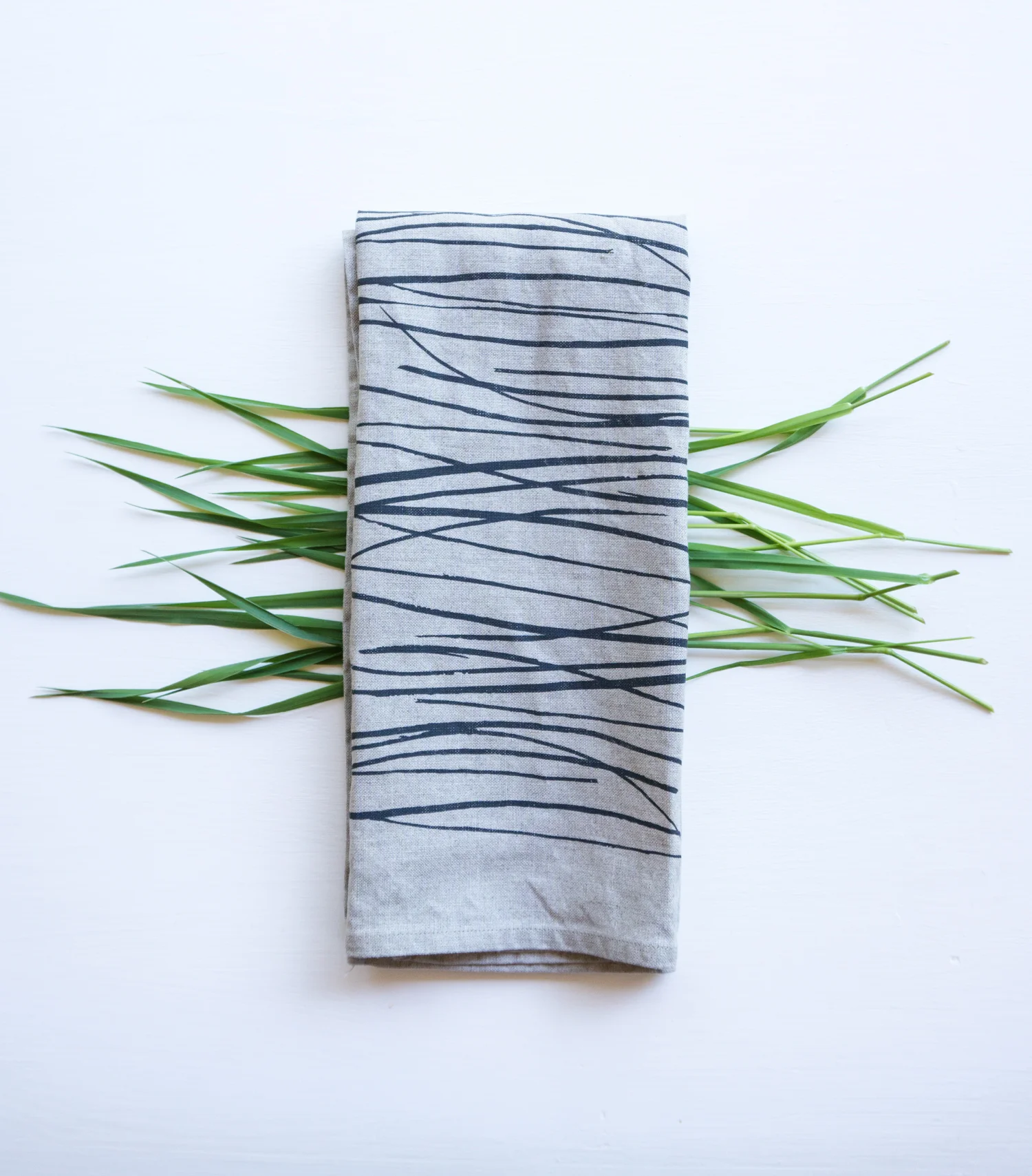 Sandra's process includes working with collected plant cuttings in her studio and taking photos of different arrangements. The final pattern is put into graphic software and a digital file is created for use by the screen printer she collaborates with.