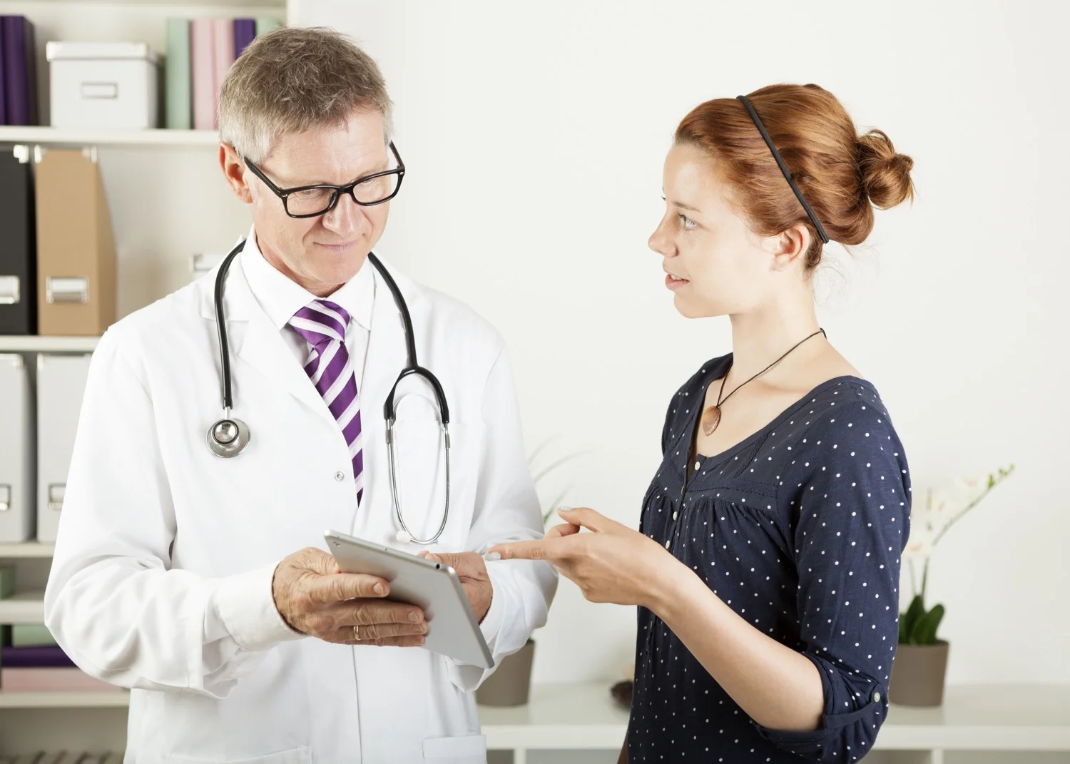 doctor and a patient woman showing something on tablet pc.jpg