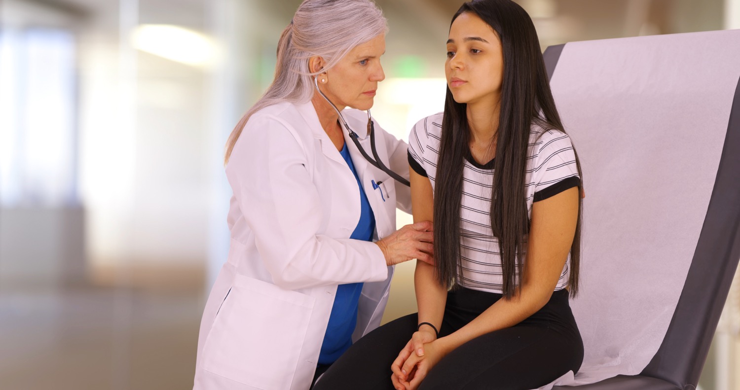 A young girl recieves her check-up from a medial professional.jpg
