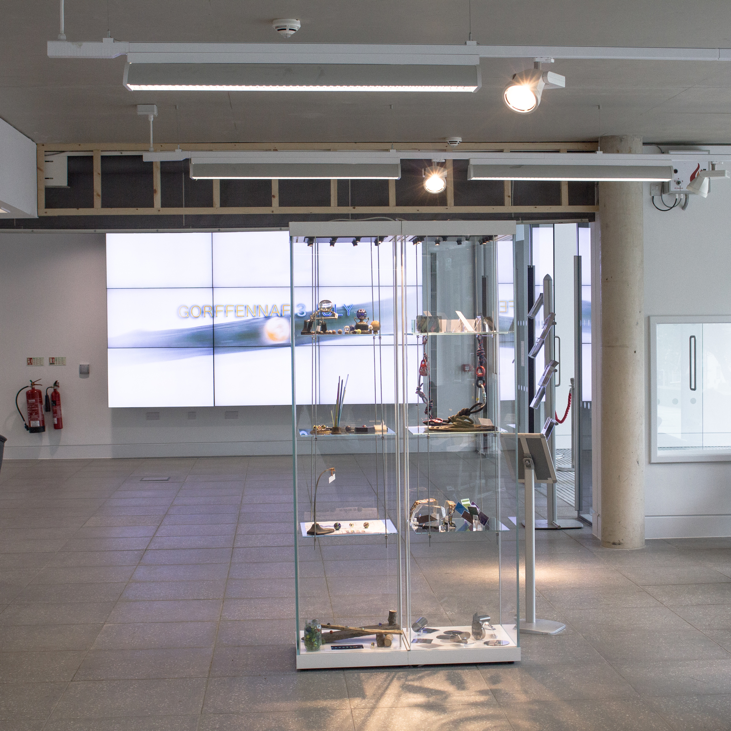 Llif/Flow display cabinet in the foyer at Pontio: The left hand side of the cabinet in the picture below, with the Vertical Light and Dance experience Synthesis project (running concurrently) in the right hand side... and our promo film in the background.