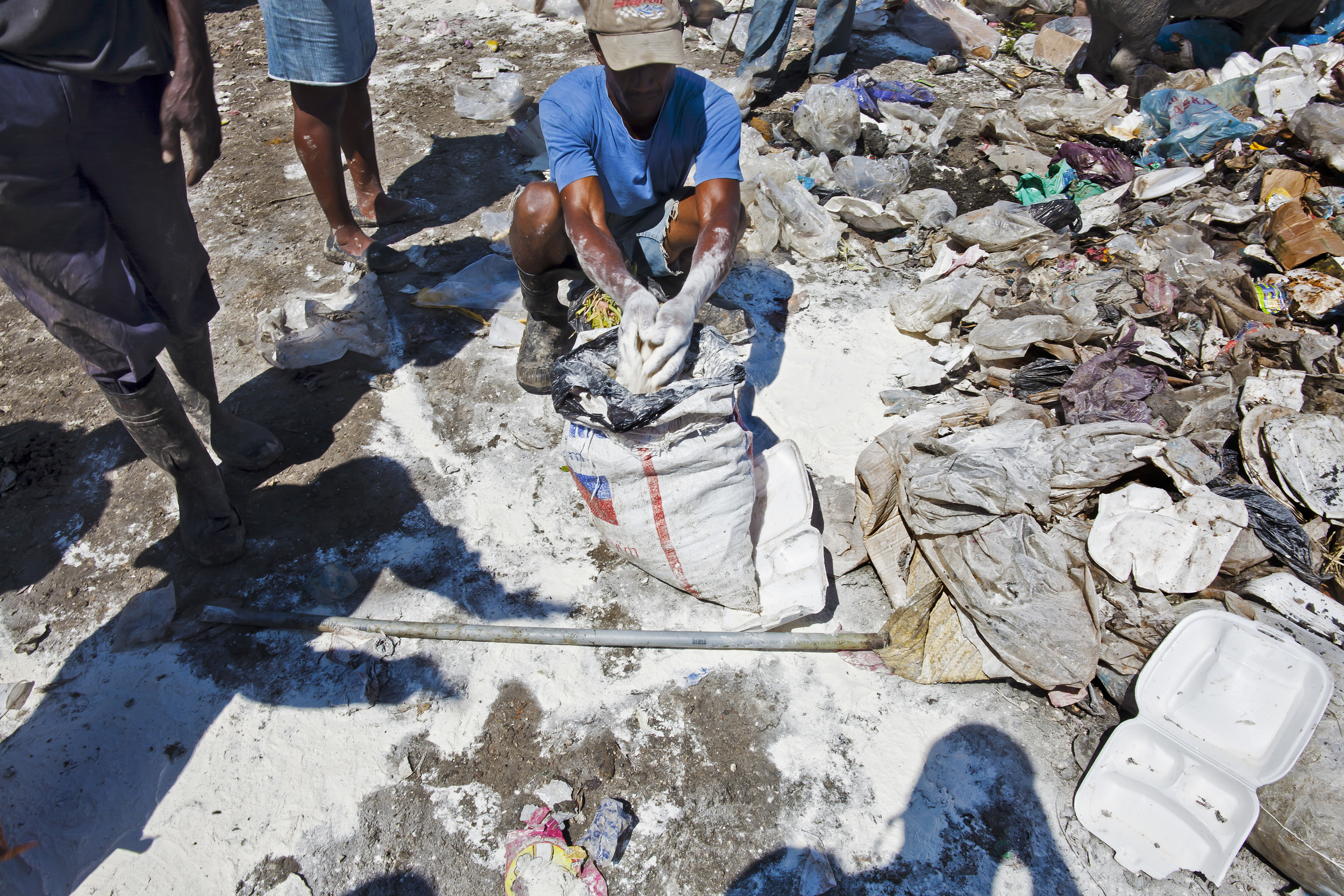 Man scoops up flour in a landfill