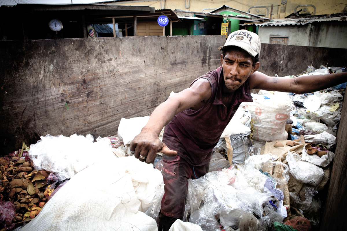 A man sorts through recyclables inside a large dumpster. Barranquilla. Colombia 2014.