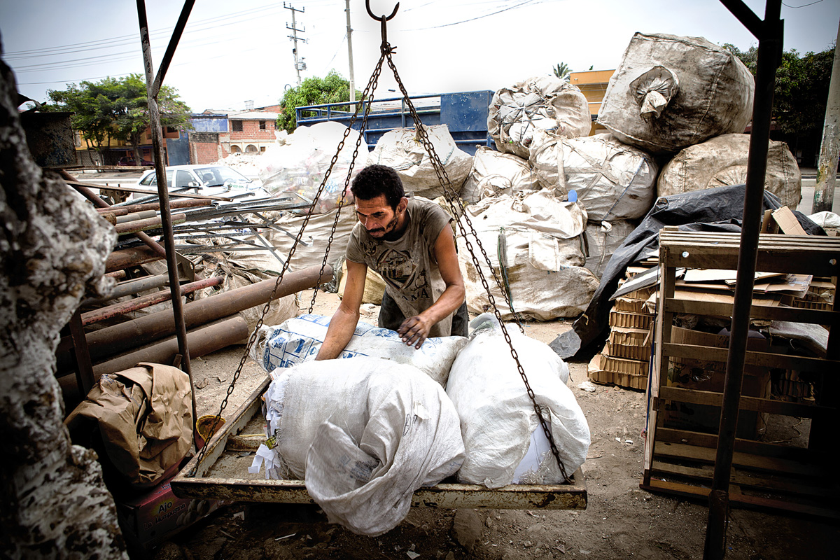 A man weighs materials to be sold to Jimmie's business. Barranquilla, Colombia 2014