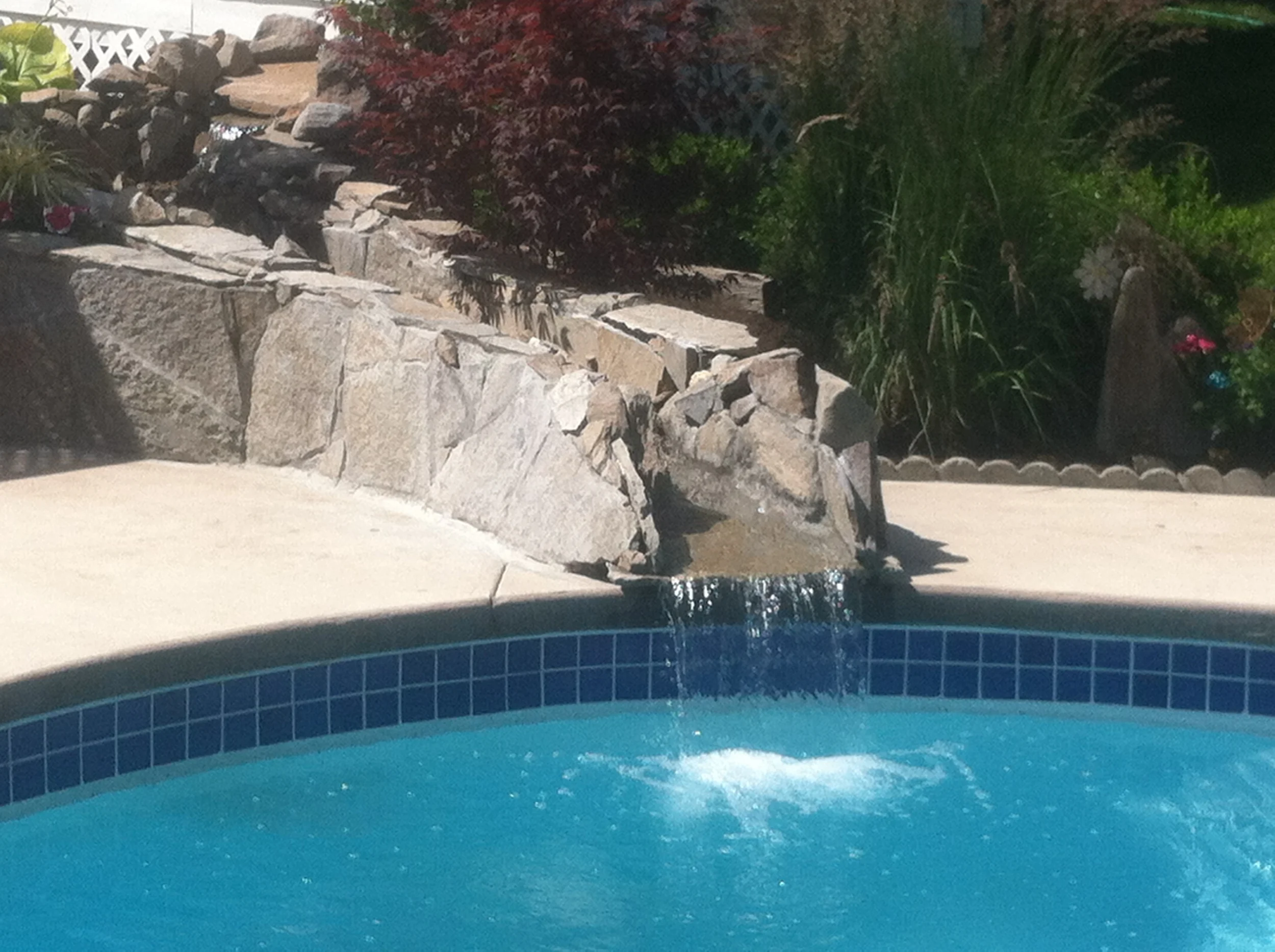 Water feature pouring into pool