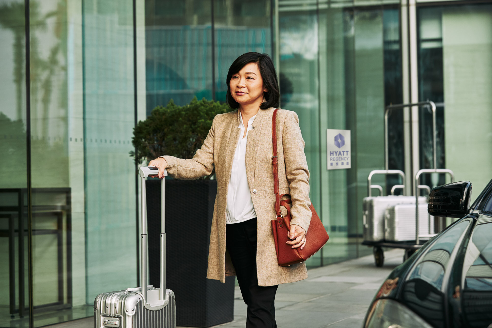 World-of-Hyatt-Business-Traveler-Woman-Rolling-Luggage-Outside.jpg