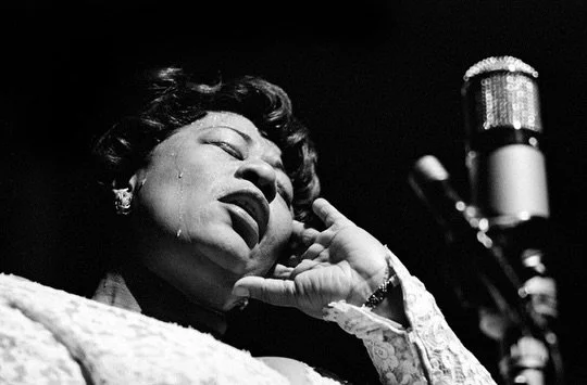 In the summer, synesthesia abounds. Sunblock smells like the surf on skin, blueberries taste like a blanket in the grass, and the solo of a saxophone sounds like a breeze on a sweltering night. In this sense the photographs of Herman Leonard are doub