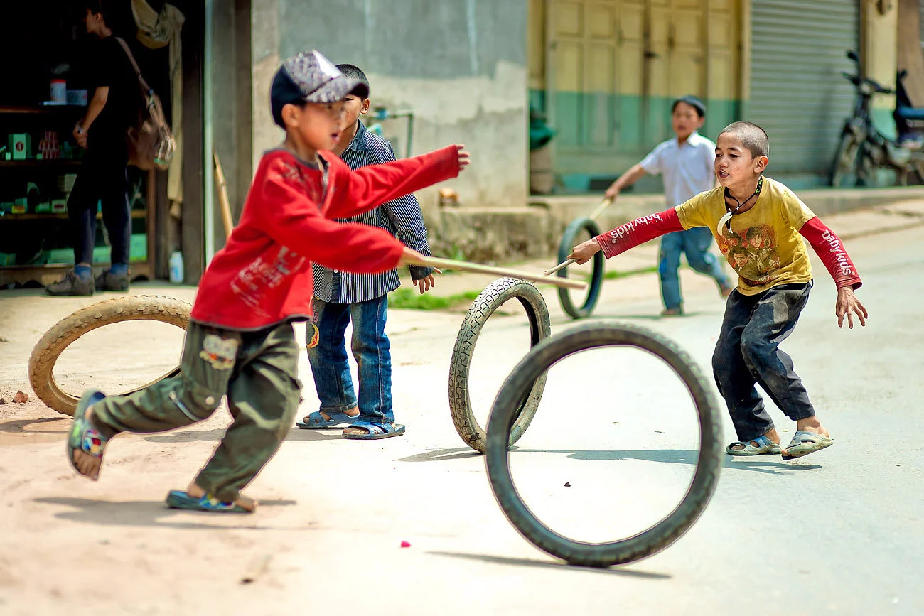 Boys play with old bicycle tires - Phongsali, northern Laos