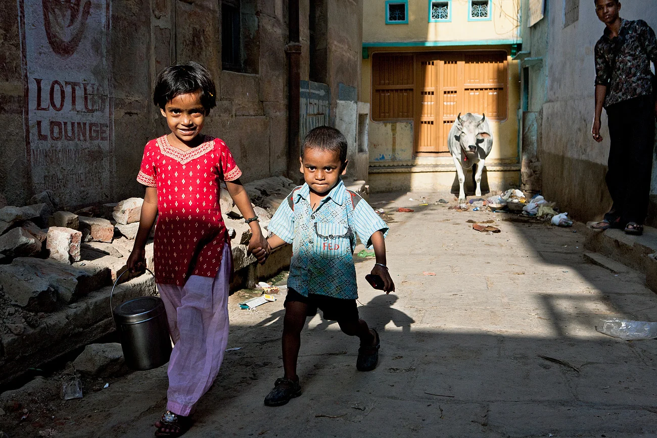 Children carrying milk through the narrow streets of the old town - Varanasi, Uttar Pradesh, India
