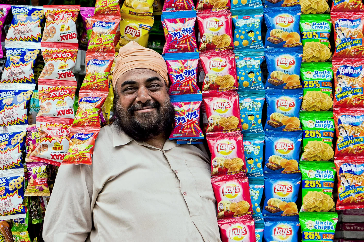 A snack vendor in the entrance to his store - Amritsar, Punjab, India