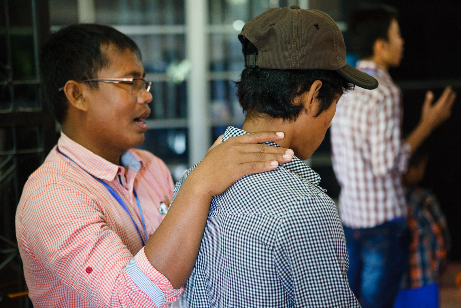 Narith's Alongsider mentor, Kimyan, praying for him at camp