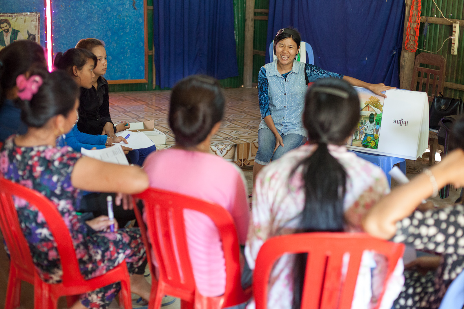 Serey teaches the 8 commitments of an Alongsider - using a flipchart