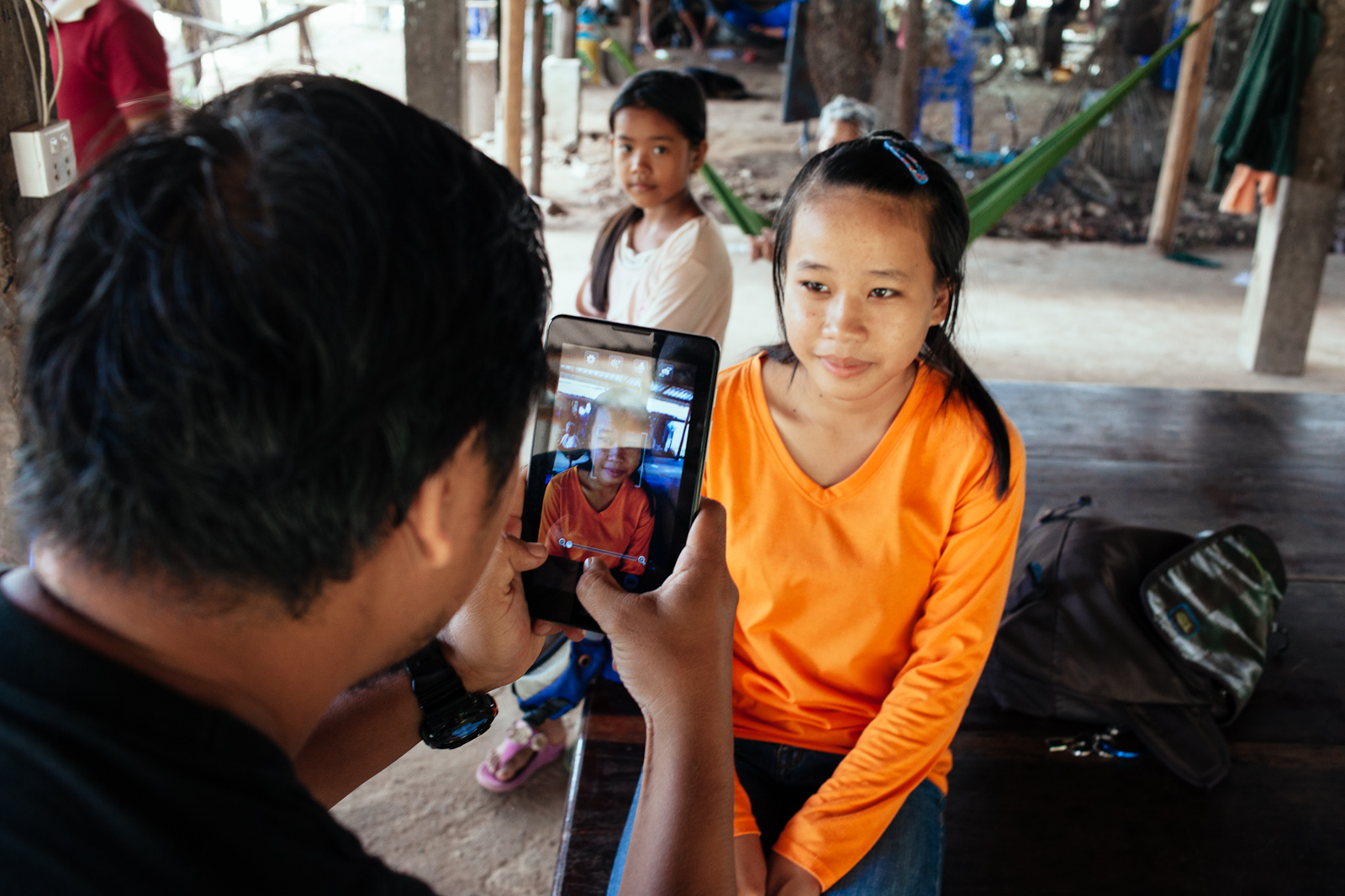 Phearom, an Alongsiders Cambodia staff, takes a photo of Matha while Esara watches.