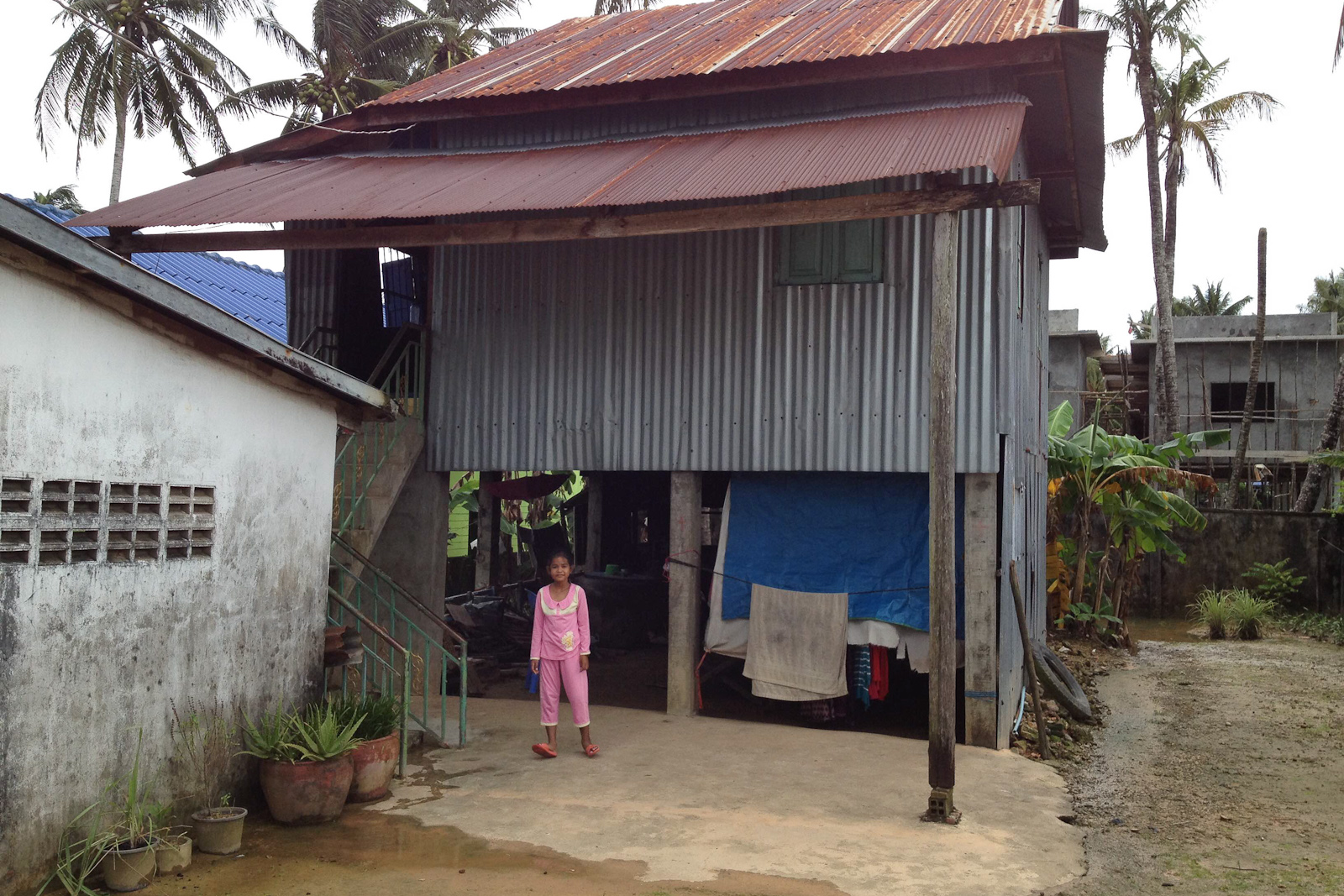 Bourmey standing in front of her house