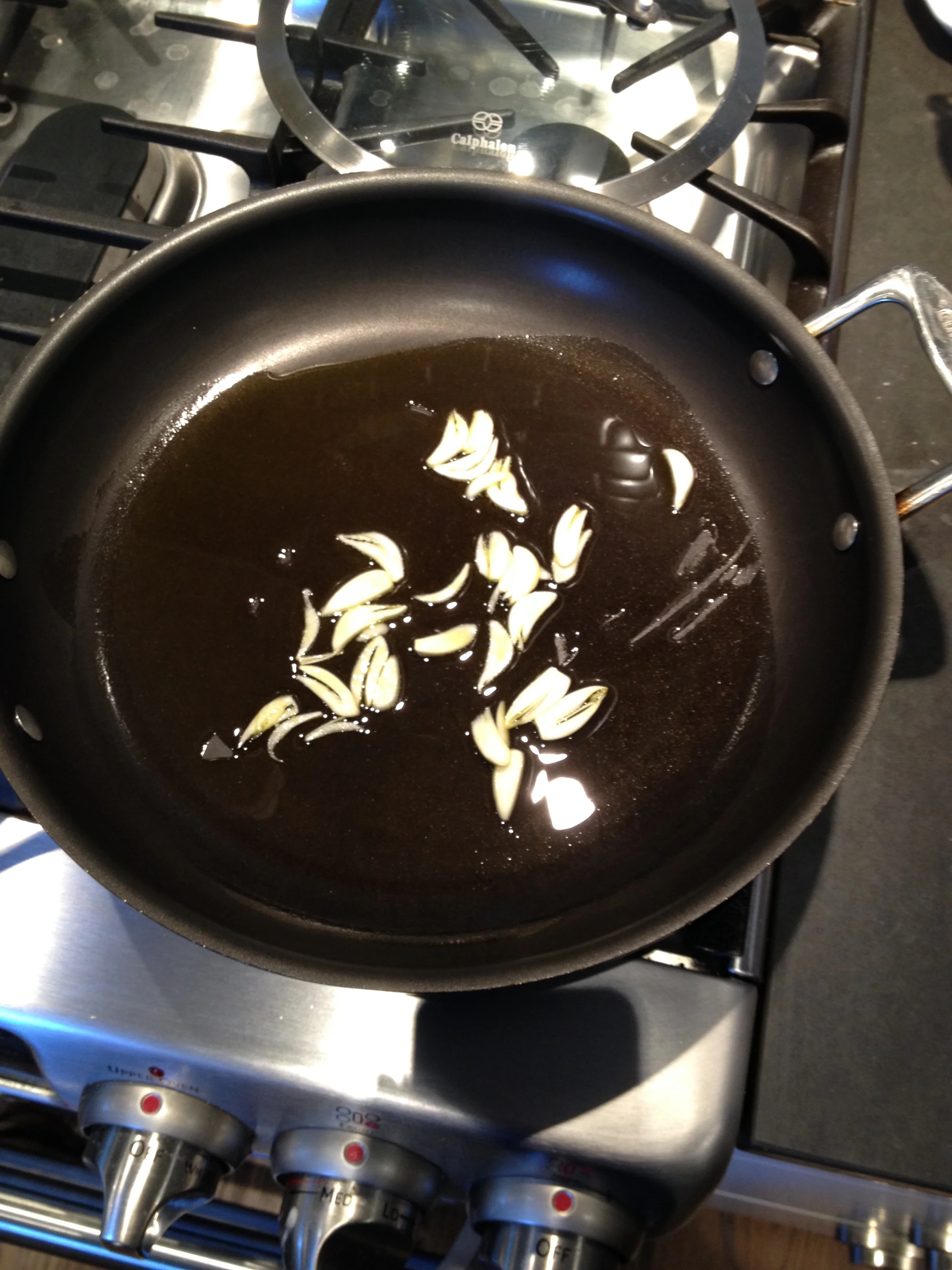 Sliced garlic cozying up with plenty of extra virgin olive oil