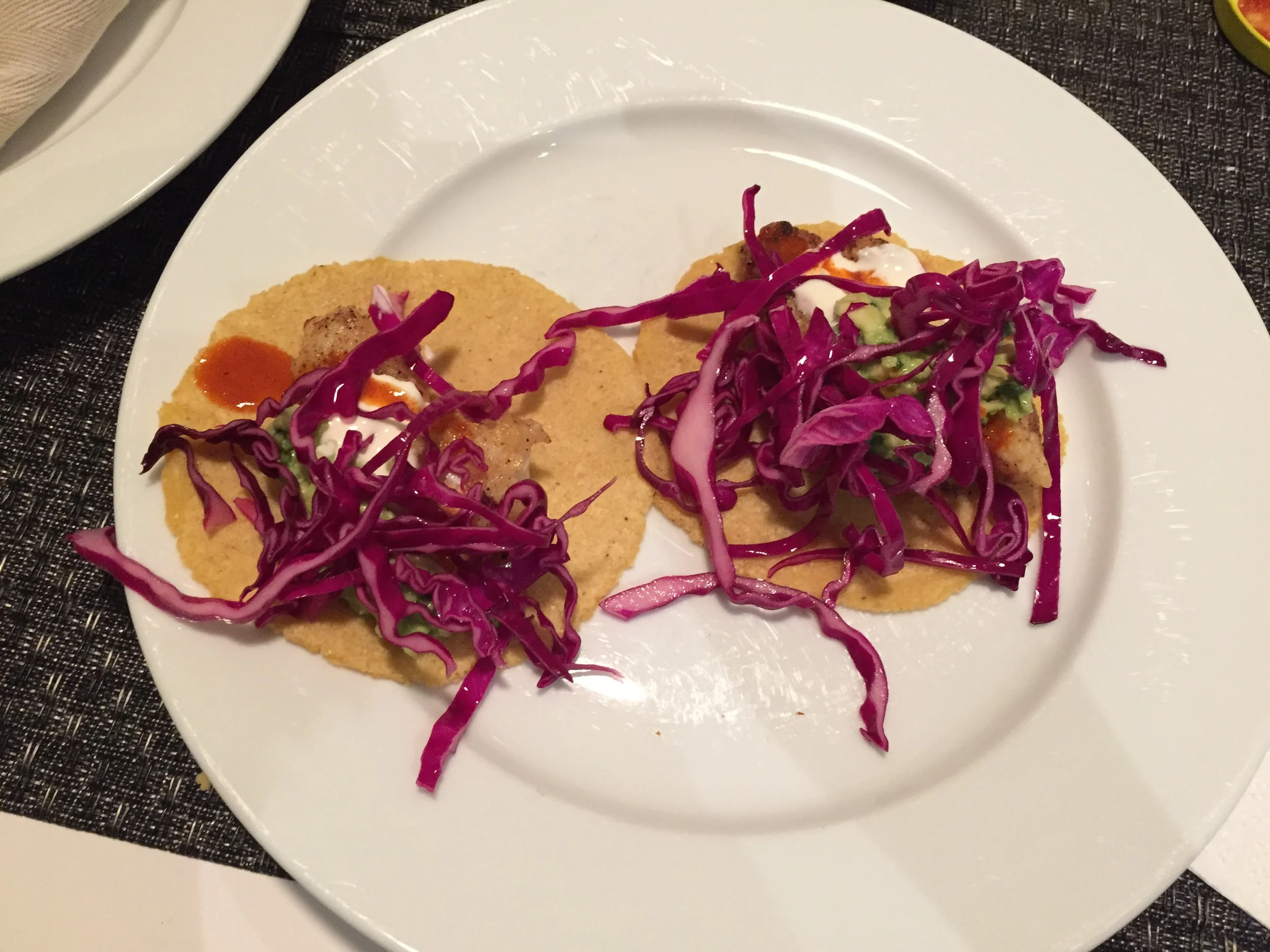 Fish tacos with guacamole, lime crema, tapatio hot sauce, and red cabbage slaw