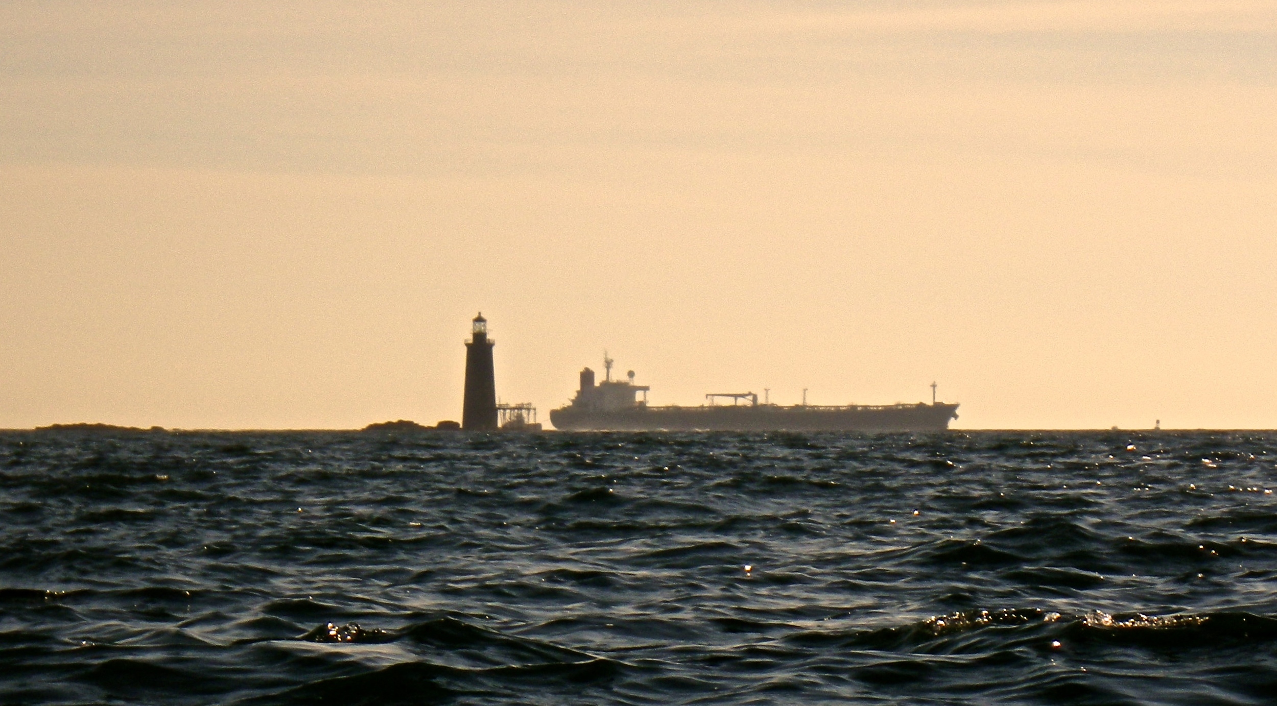 A crude oil tanker passes behind Ram Island Ledge Lighthouse (Photo: Joe Guglielmetti)