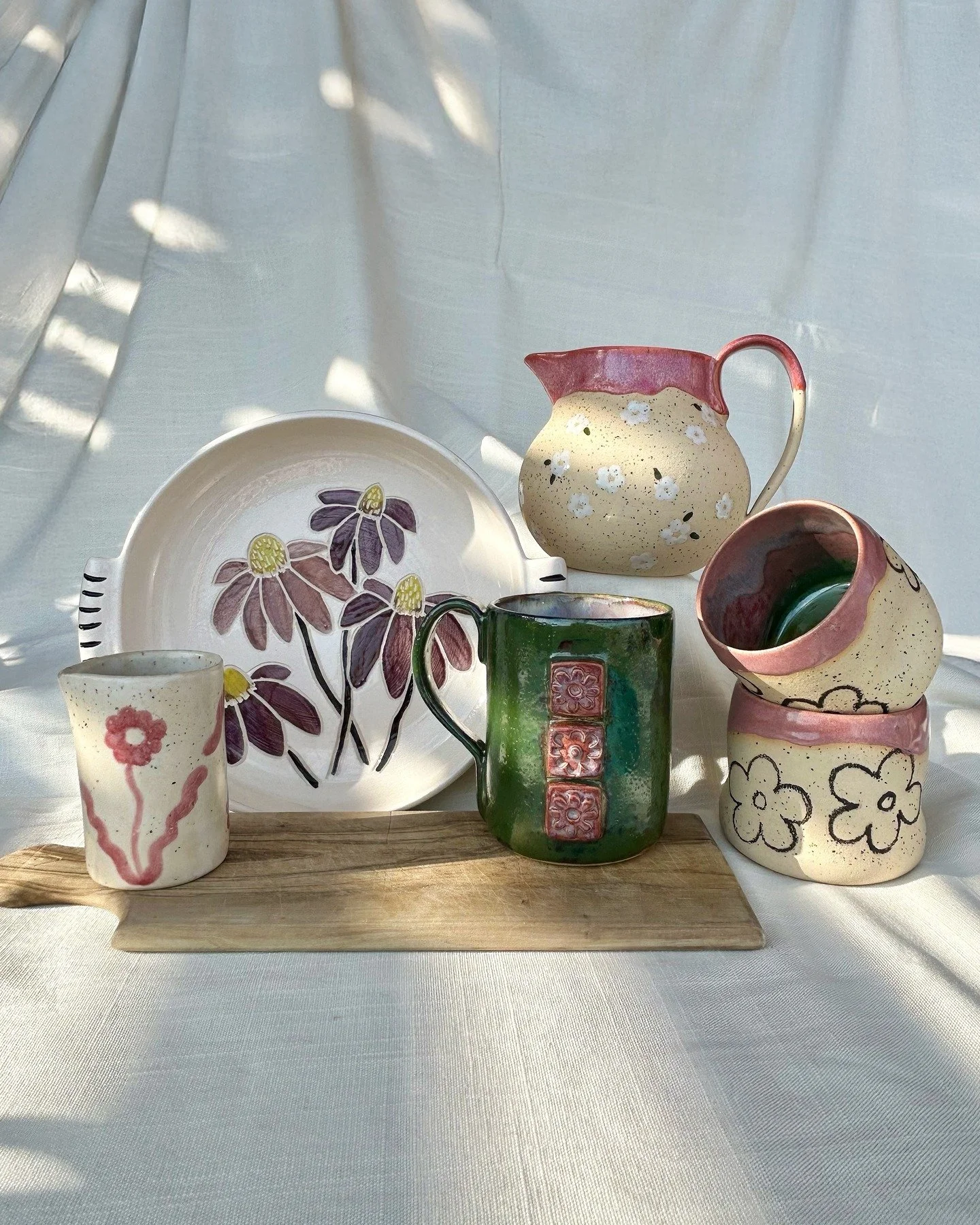 Here they are &mdash; the whole flower crew 🌸

My first real collection, all tied together with color and floral details.

Three have already found new homes, and the rest are still up for grabs. DM to claim yours!

#wheelthrownpottery #wheelthrown 