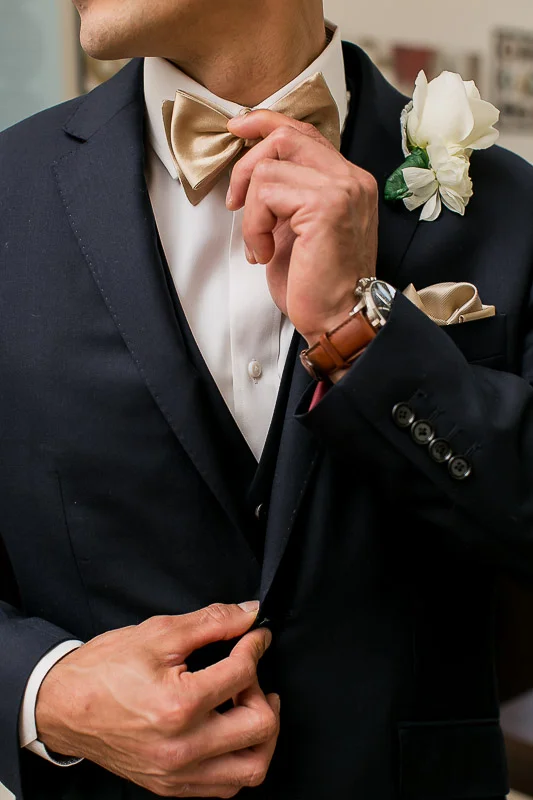  Groom wedding details with gold bowtie, blue suit, watch and pocket square 
