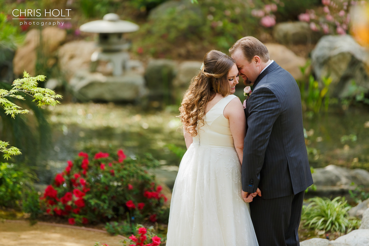  Bride and Groom romantics at Storrier-Stearns Japanese Garden in front of koi pond 