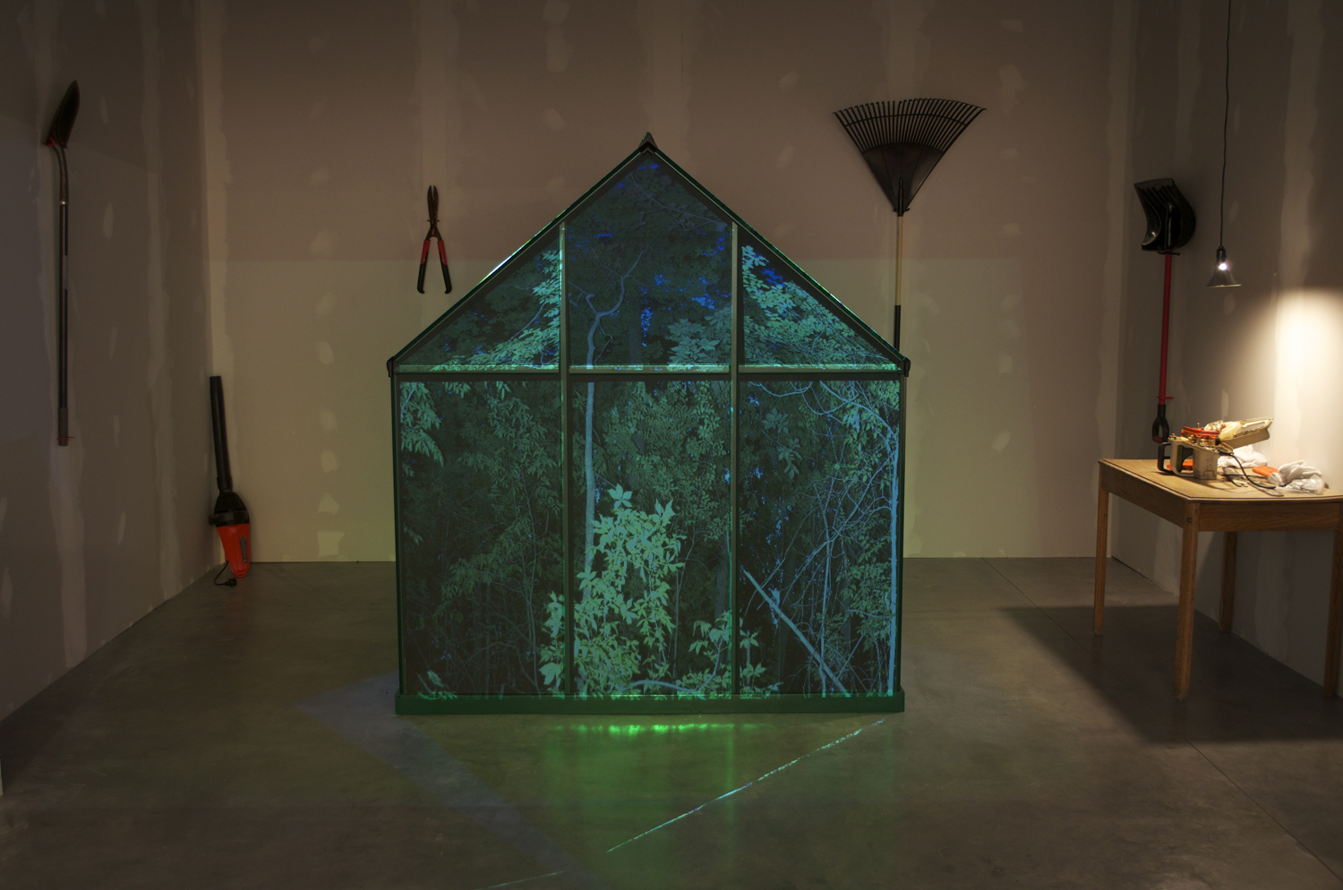 They're Us
10' x 25' x 25'
garage
2013
Hollowed log fort and
white
supremacists' websites within a greenhouse,
gardening tools, chainsaw, 360° projection onto greenhouse, and a layered
audio loop of lawnmowers circling
Hate group