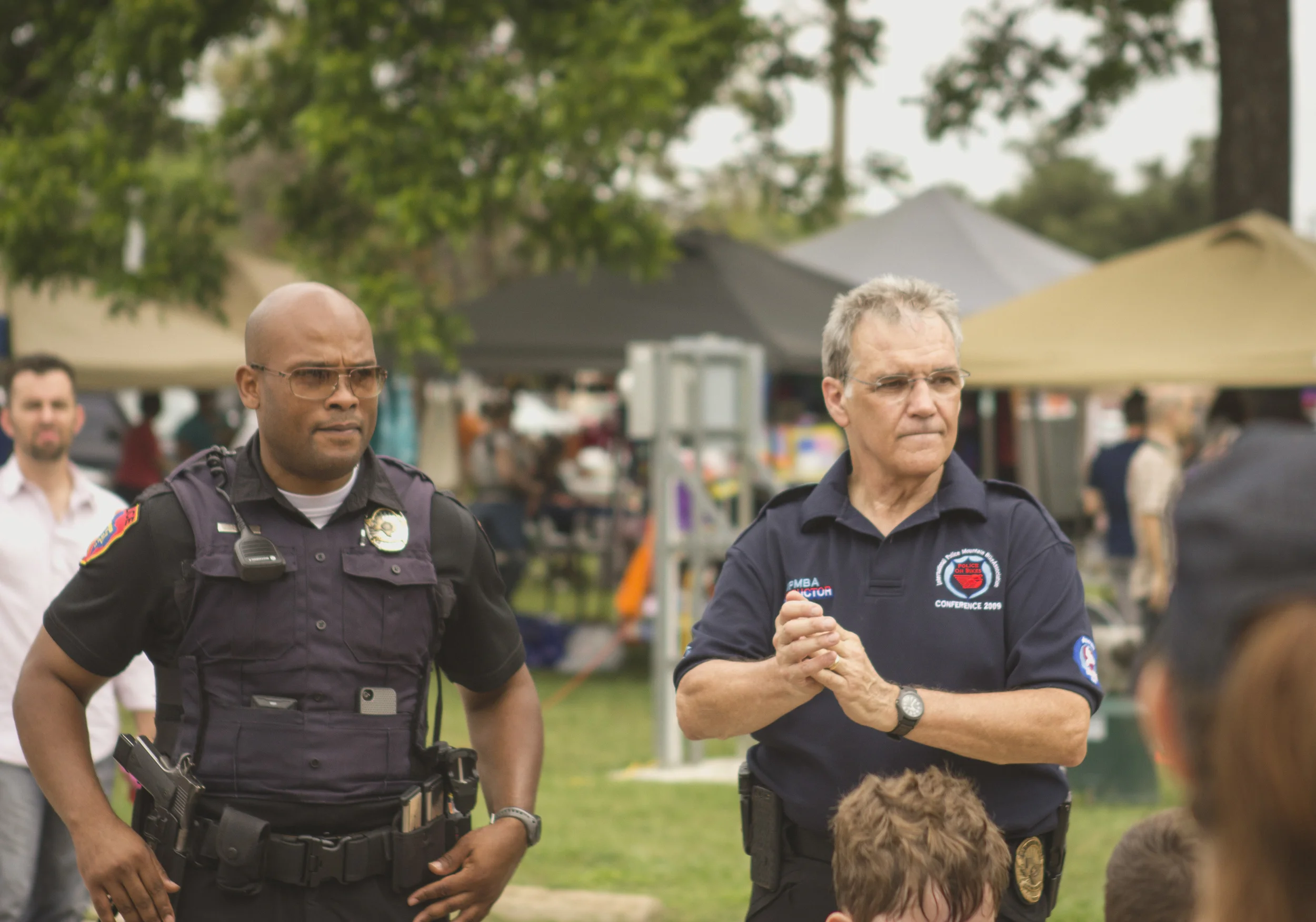 Denton Police Lt. Thomas Woods and Denton PD bike officer, Donnie Carr, look on as kids practice bike safety. 