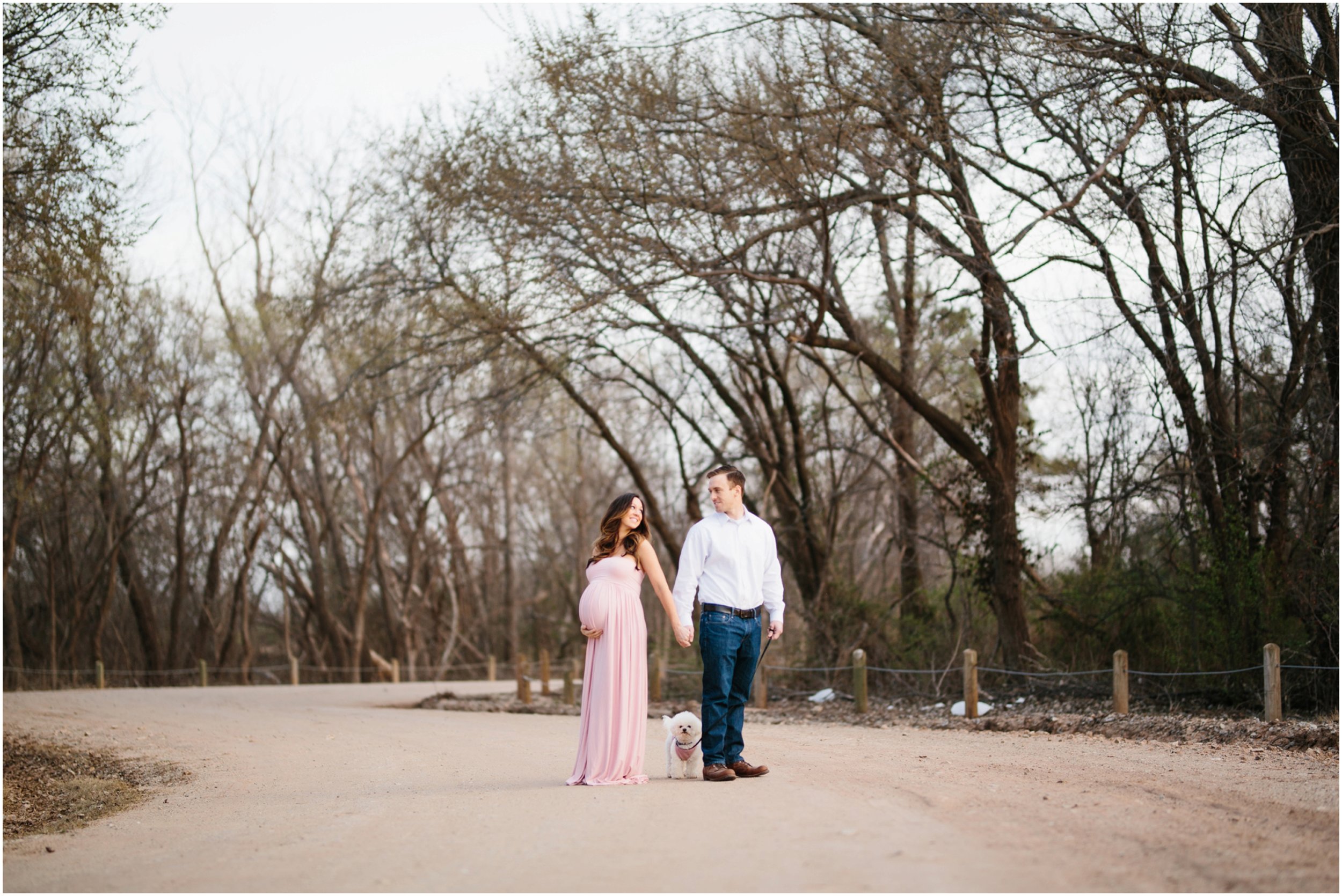family with dog maternity photos outdoors on dirt road at lake hefner