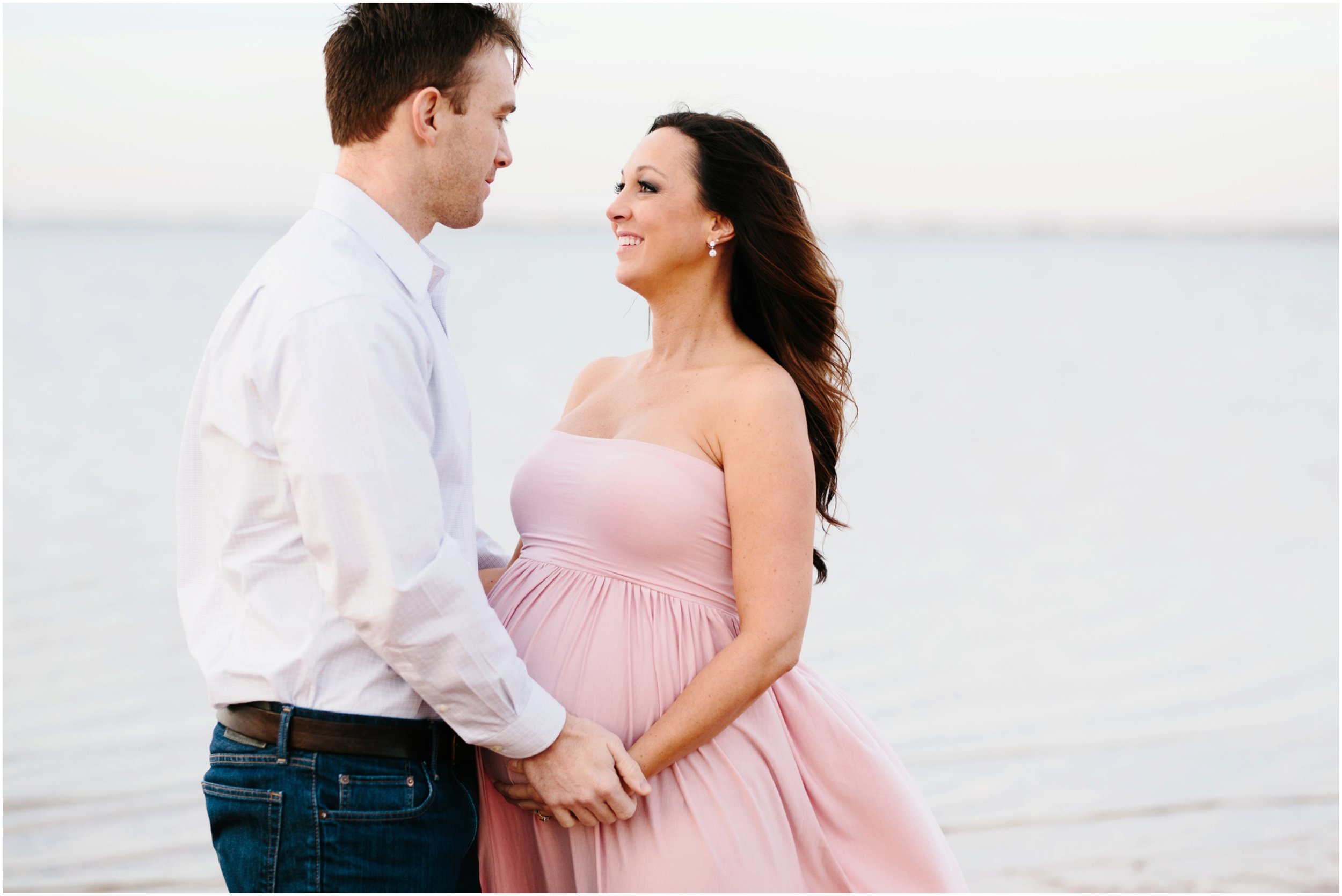 expecting parents holding hands on beach in maternity photos edmond ok