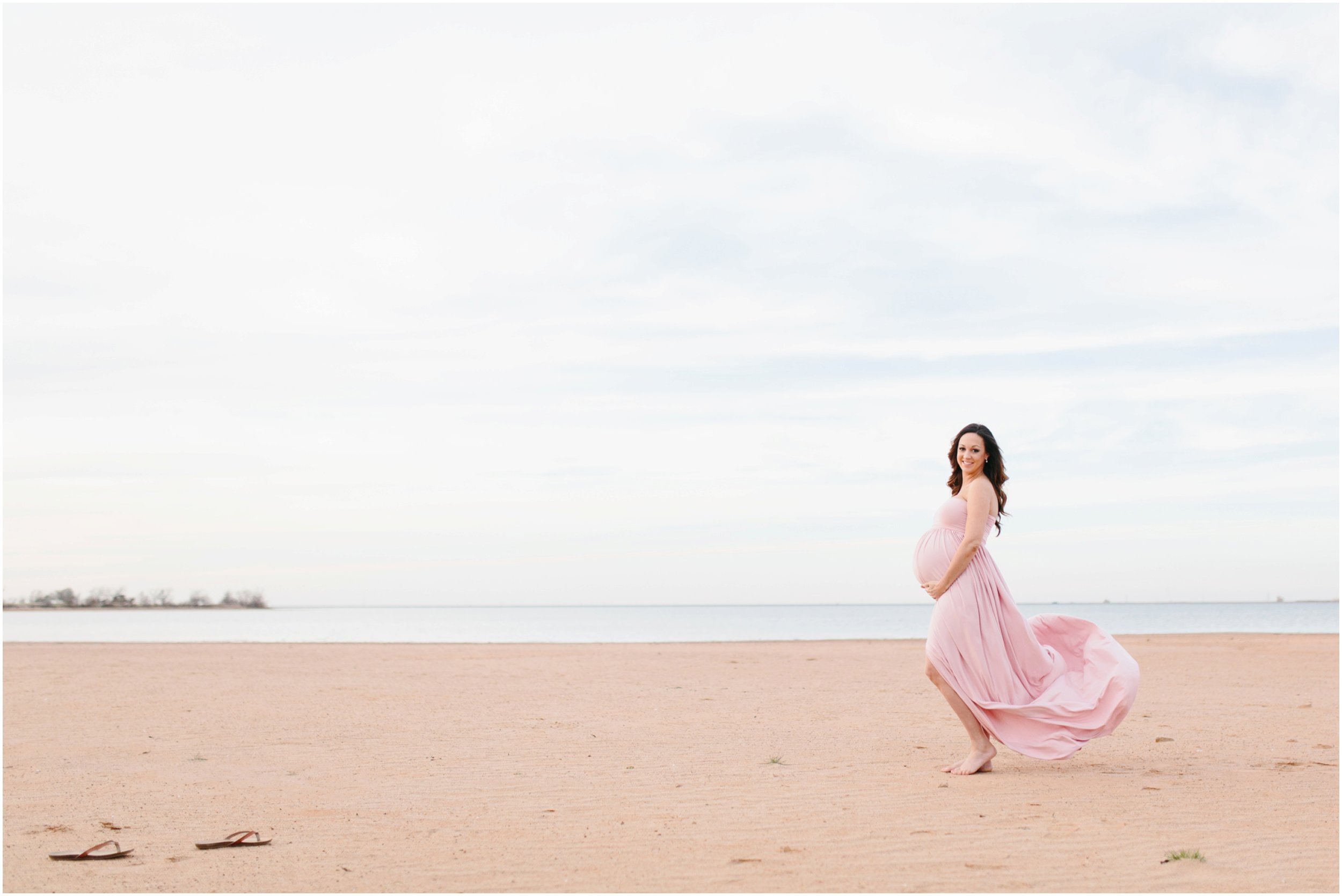 maternity flowy dress blowing in wind on beach